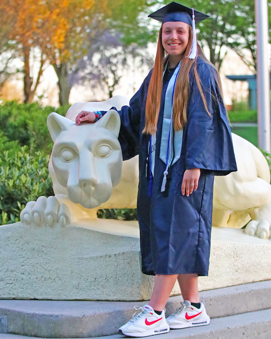 kendis_butler_poses_with_her_commencement_regalia_near_the_lion_shrine_at_penn_state_harrisburg