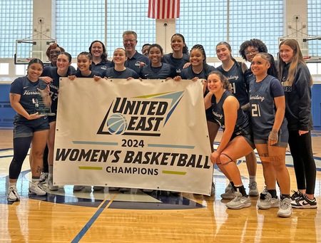 penn state harrisburg womens basketball team poses with the united east championship banner
